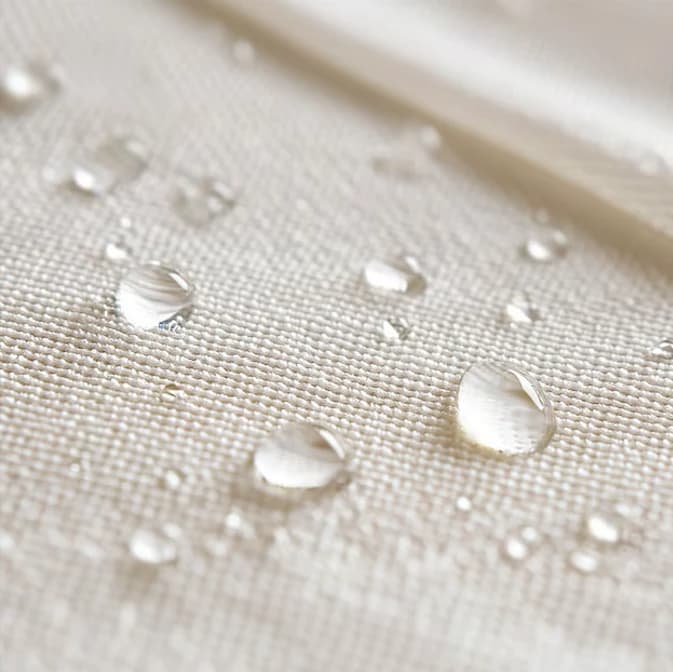 Gotas de água perolando sobre tecido claro protegido pela blindagem